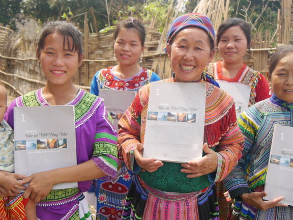Vietnamesinnen freuen sich, dass sie einen Alphabetisierungskurs abgeschlossen haben.
